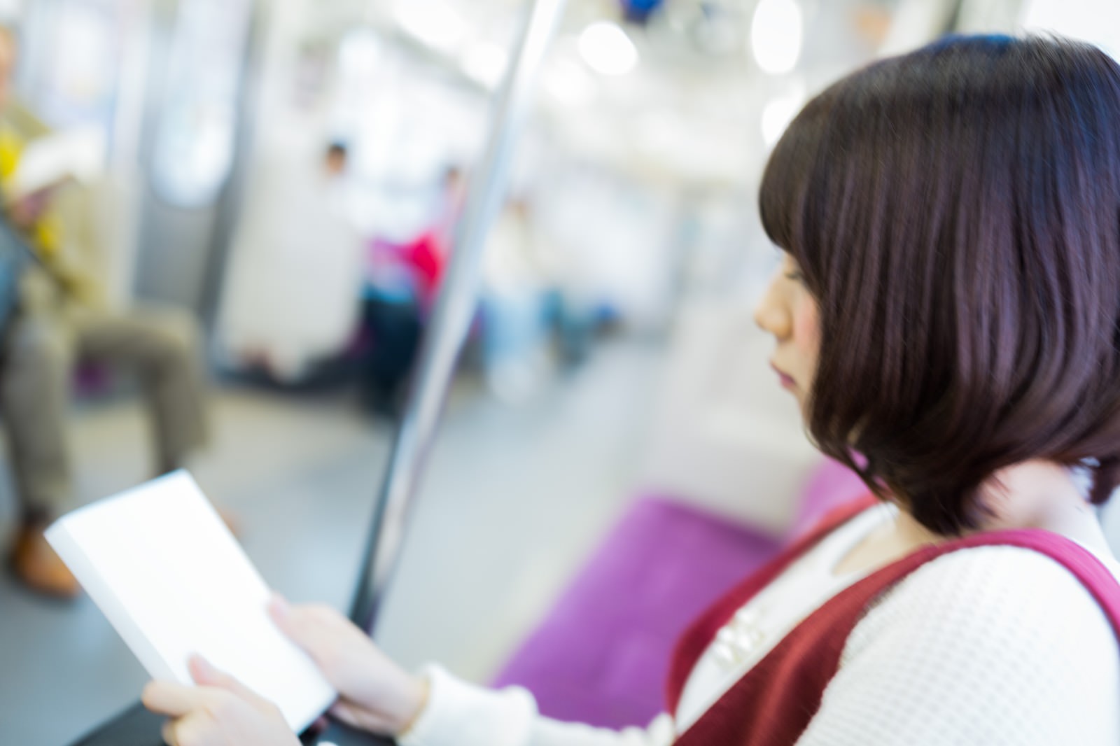 電車内で参考書を読む女性